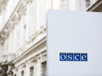 Close-up shot of the OSCE logo at the Secretariat entrance.