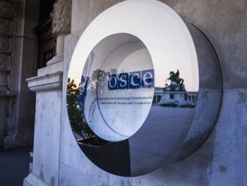 The OSCE logo next to the main gate outside of the Hofburg, Vienna.