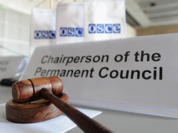 The OSCE flags and a gavel at the start of a meeting at the Hofburg.